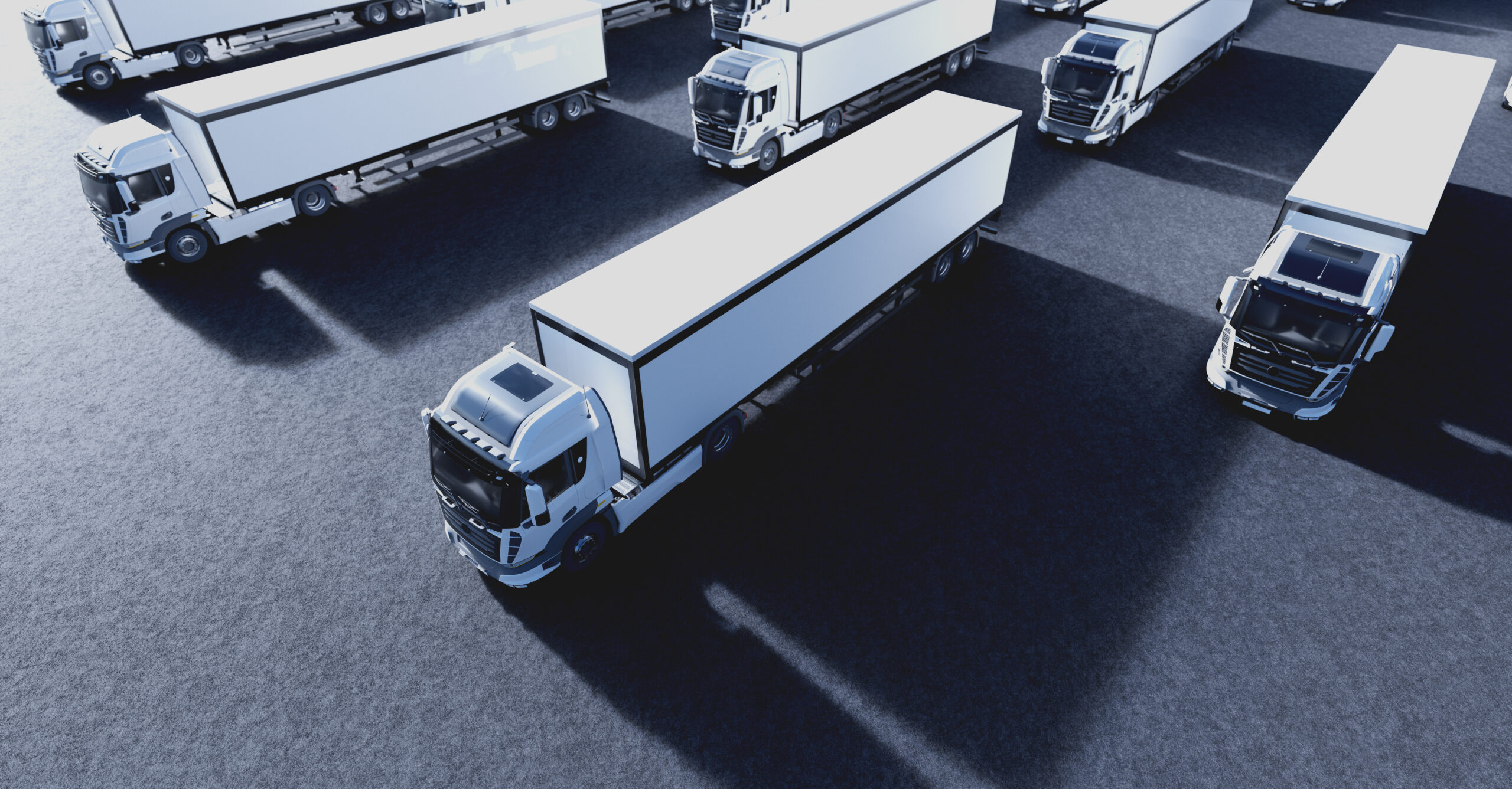 An aerial perspective of a synchronized fleet of articulated HGVs parked at a distribution hub.